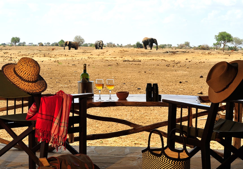 Elephants on the red plains of Tsavo East, seen from a camp